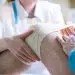 doctor bandages her patient knee